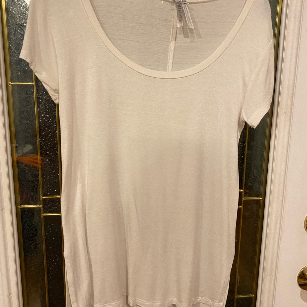 White Scoop-necked blouse with deep side slits for easy movement.